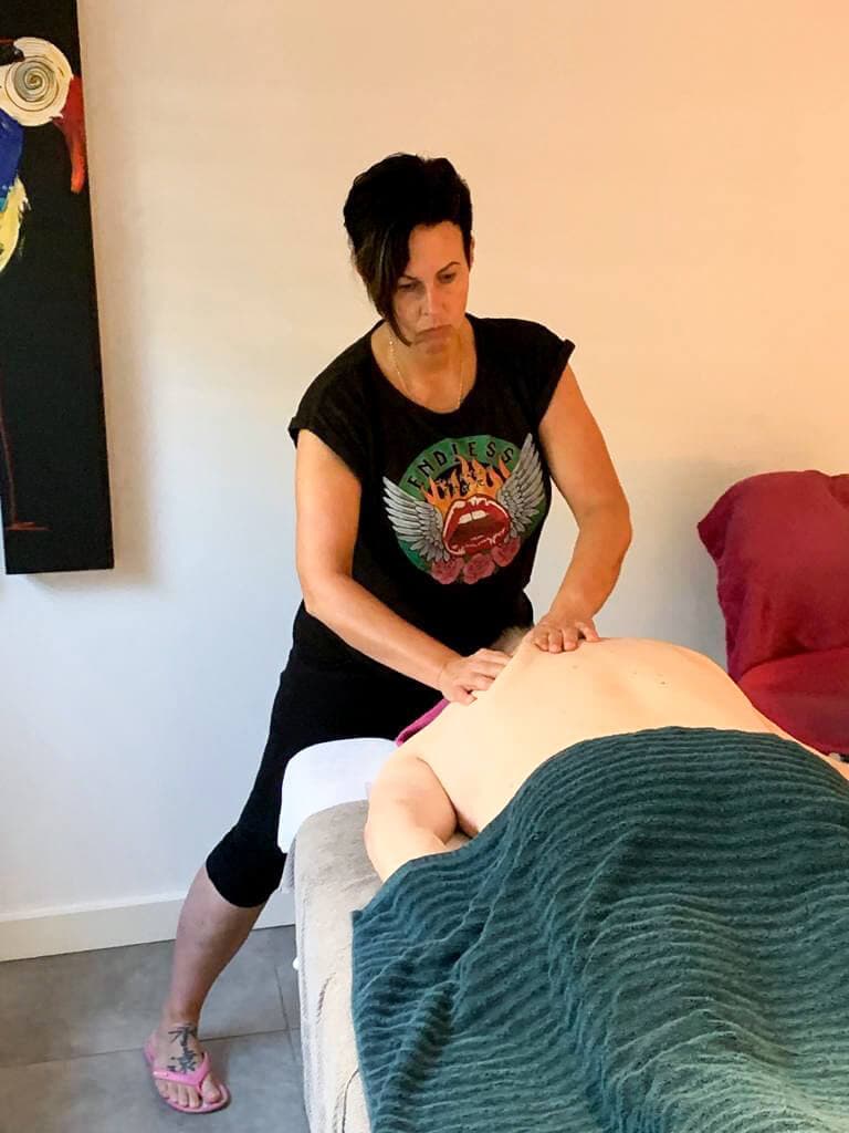 Fasciatherapie: met beide handen wordt het bindweefsel op de rug van een cliënt losgemaakt